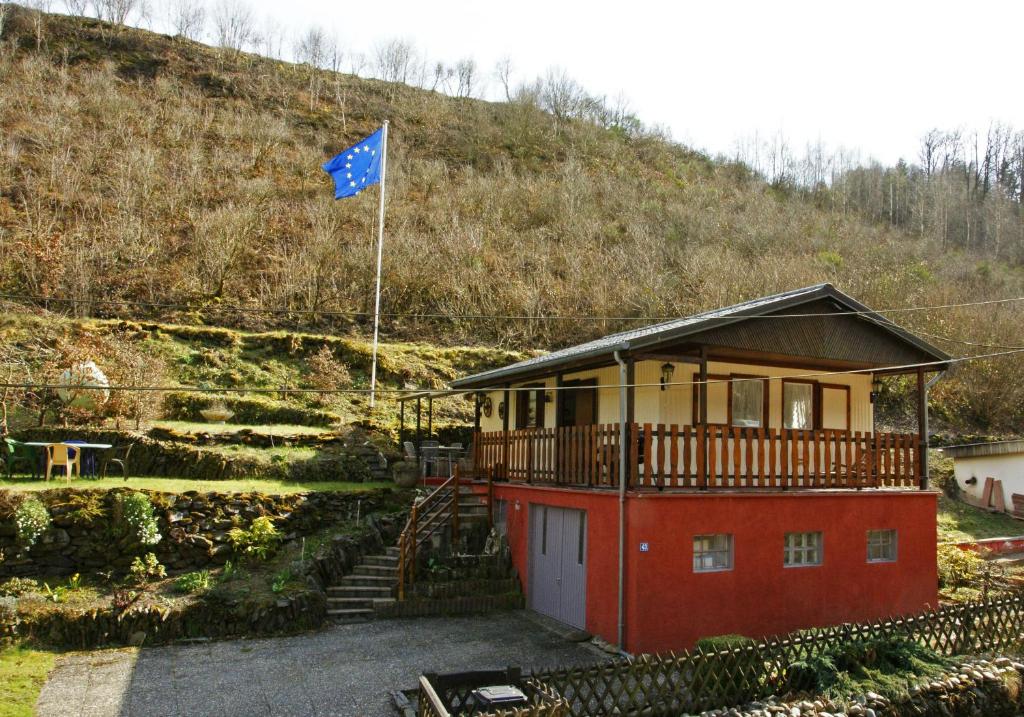 een klein huis met een vlag op een heuvel bij S.C.I. Rannerbaach in Dirbach