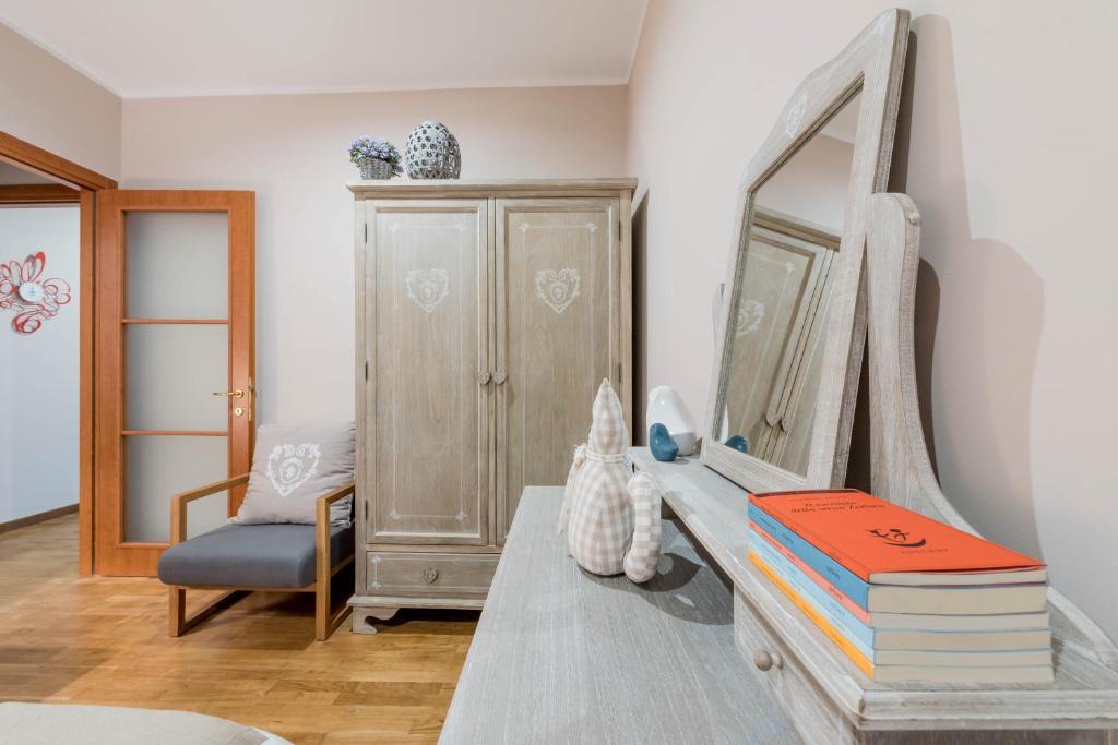 een kamer met een tafel met boeken en een spiegel bij Mignon - Appartamento di charme in Turijn