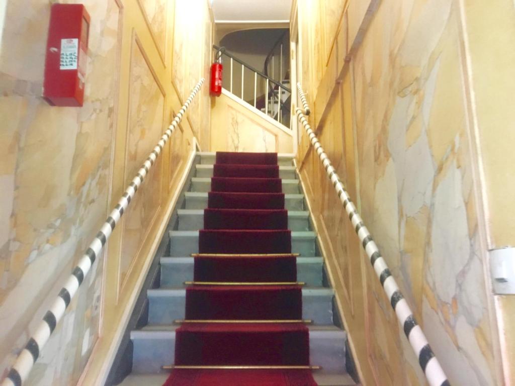 una escalera en un edificio con alfombra roja y azul en Hôtel du Centre, en París
