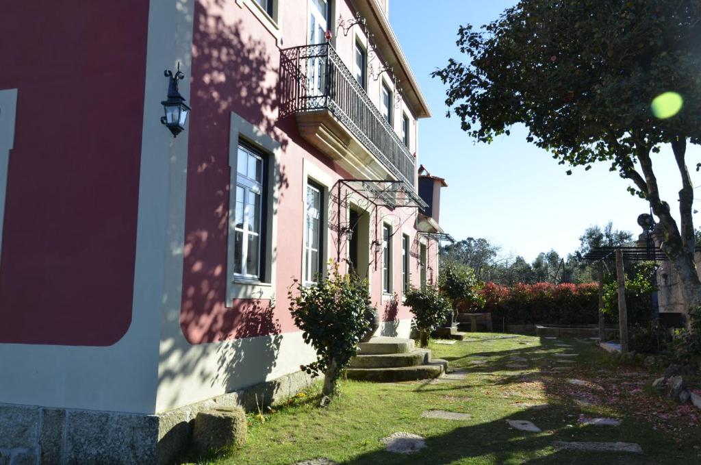 een roze gebouw met een balkon aan de zijkant bij Solar da Motta Douro Boutique Home in Ancede