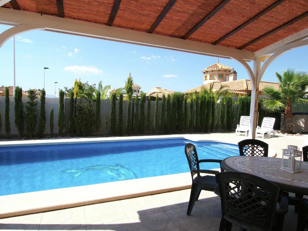 une terrasse avec une table et des chaises ainsi qu'une piscine dans l'établissement Luxurious Holiday Home in Mazarron with Private Pool, à Mazarrón