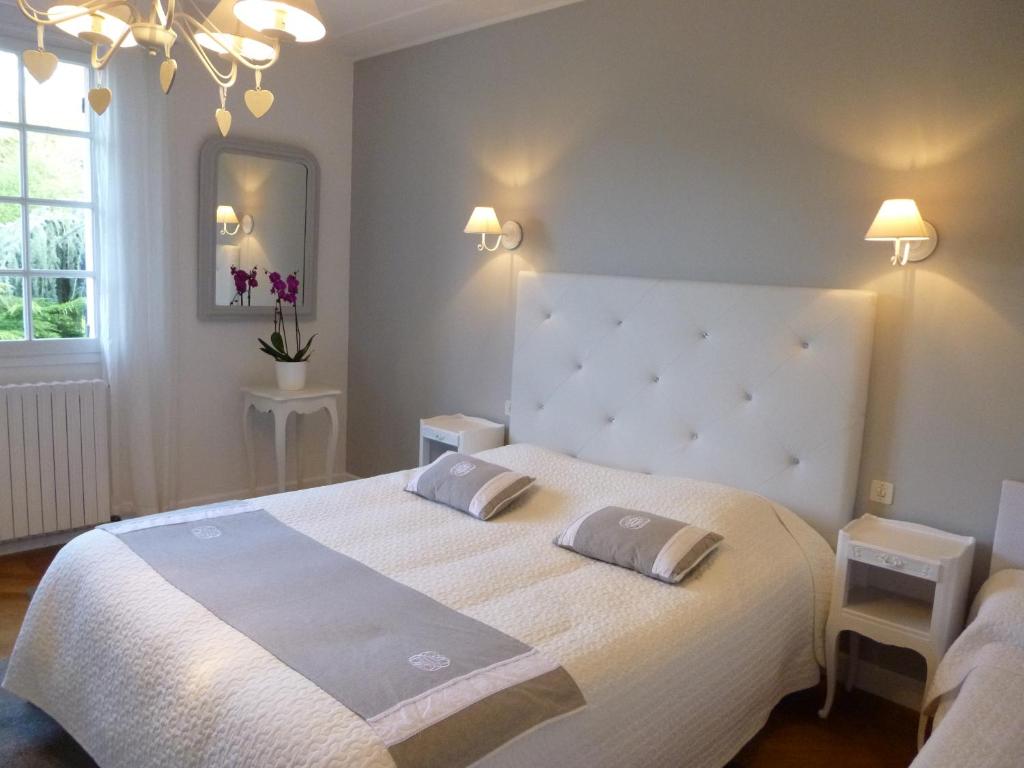 1 dormitorio con 1 cama blanca grande y espejo en Etape Zen, en Illiers