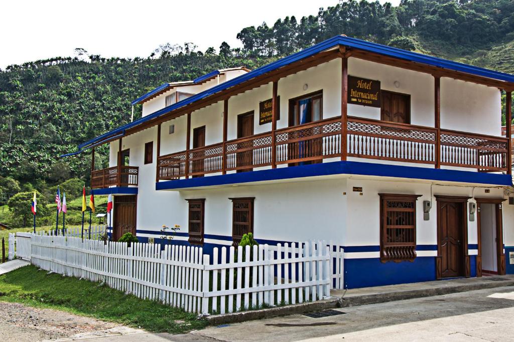 a blue and white building with a white fence at Hotel Internacional Jardín in Jardin