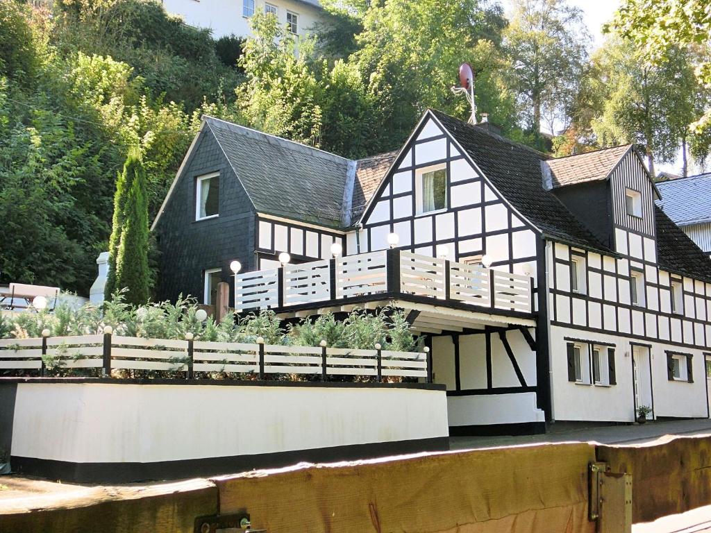 a black and white house with a garden in front of it at Charming holiday home near the ski area in Schmallenberg