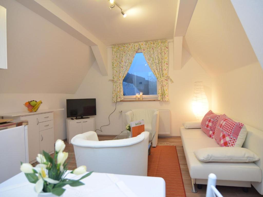 sala de estar con sofá blanco y ventana en Charming holiday home near the ski area, en Schmallenberg