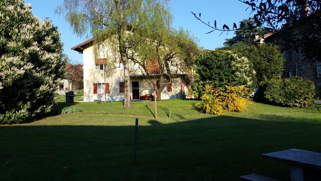 Castelveccana的住宿－Apartment Piccolo Borgo，一座树木繁茂的院子中的房子