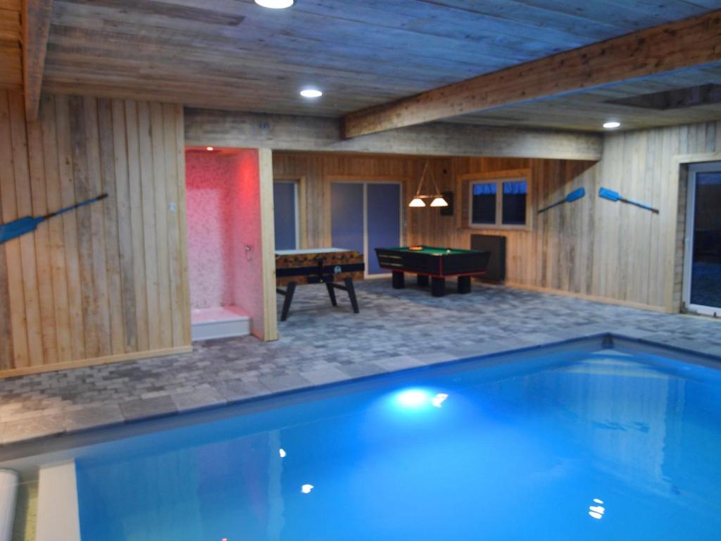a pool in a room with a ping pong table and a ping pong at Modern Holiday Home in Sourbrodt with Private Pool in Sourbrodt