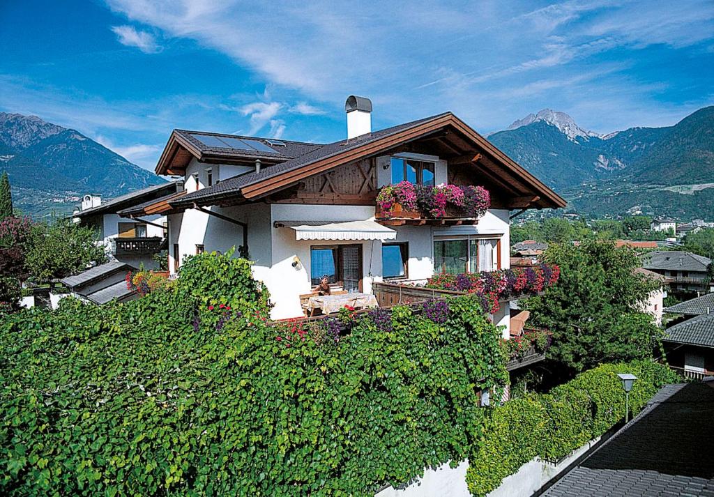 a house with a bunch of ivy growing around it at Pension Residence Sonnenheim in Marlengo