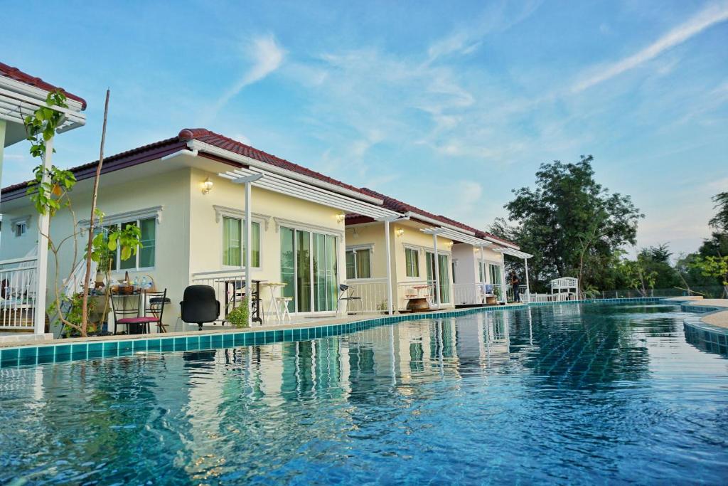 a swimming pool in front of a house at Sky and water resort in Cha Am