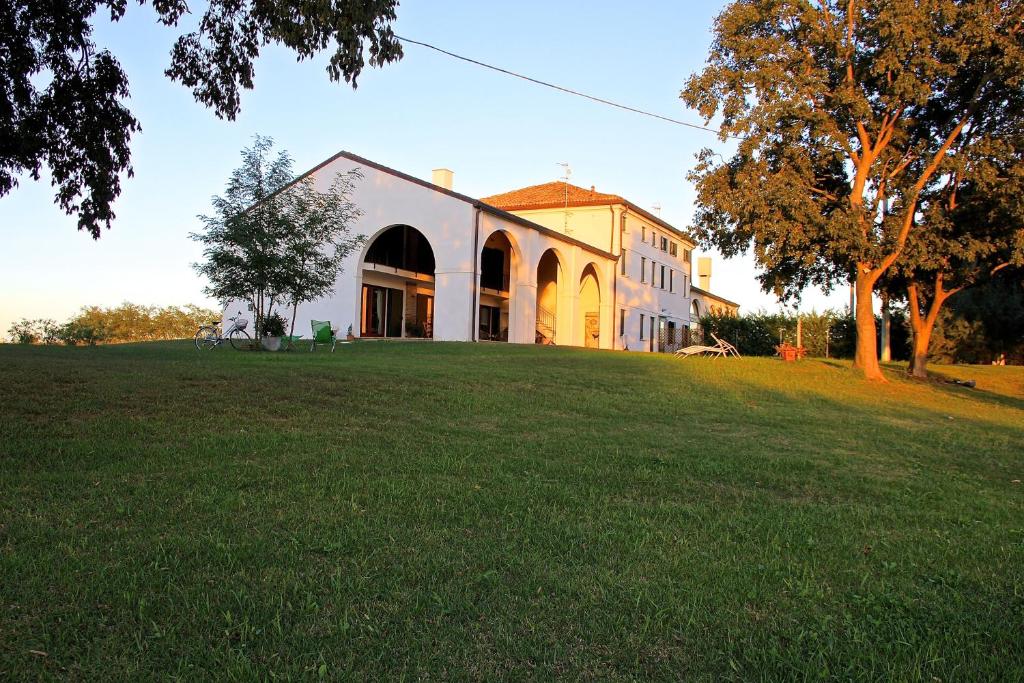 a large building on a grassy field in front of a building at Agriturismo Monte Scala in Taglio di Po