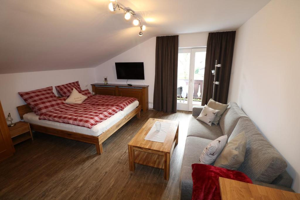 a living room with a bed and a couch at Alpen - Apartments in Garmisch-Partenkirchen