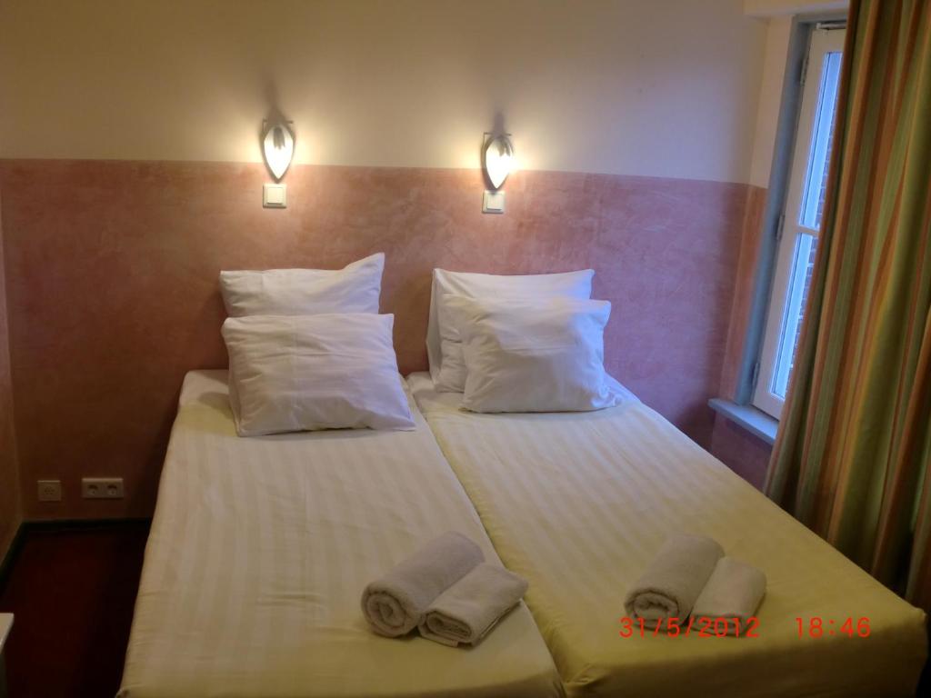 2 Betten in einem Hotelzimmer mit Handtüchern darauf in der Unterkunft Budget Hotel Neutraal in Amsterdam