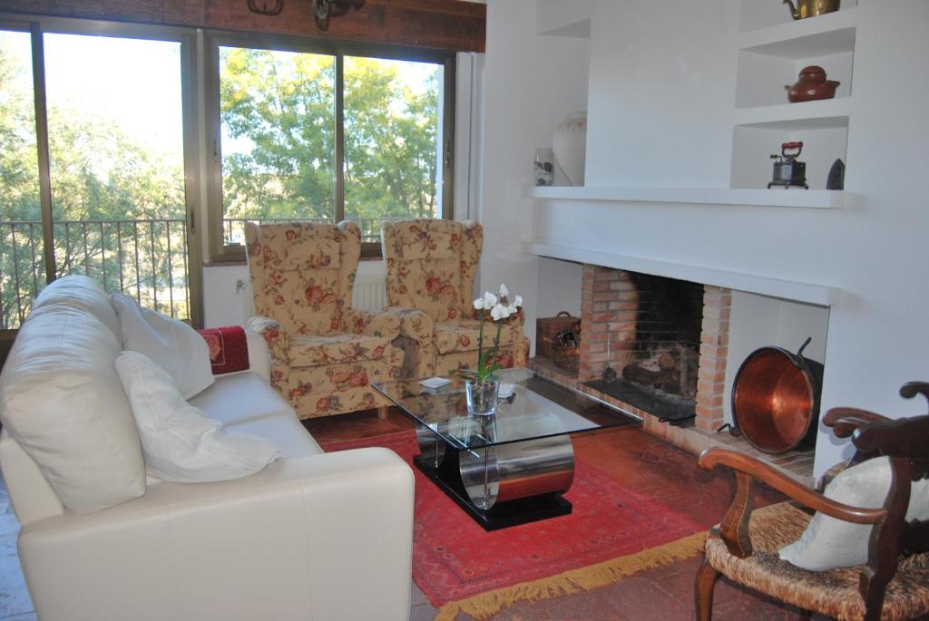ein Wohnzimmer mit weißen Möbeln und einem Kamin in der Unterkunft Casa rural Puente Mocho in Ledesma