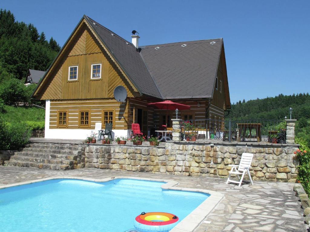 a house with a swimming pool in front of a house at villa with swimming pool in the hilly landscape in Pecka