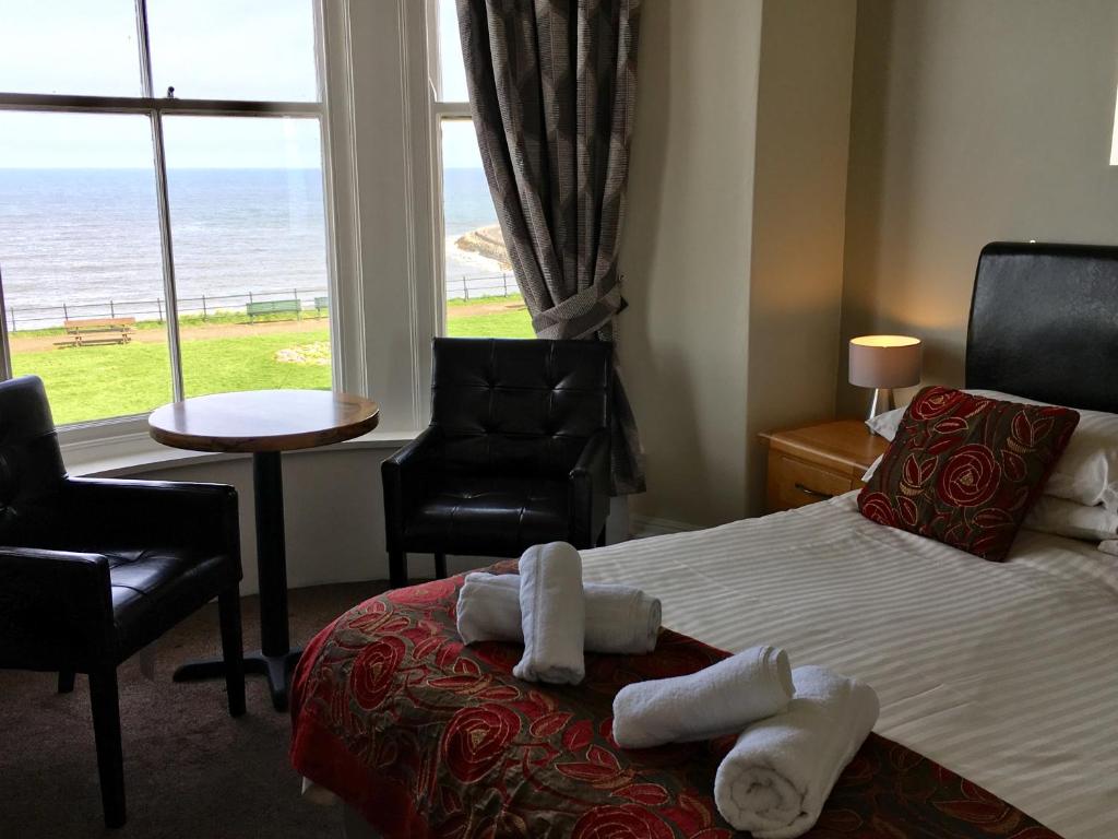 a bedroom with a bed and a window with the ocean at The Rockside in Scarborough