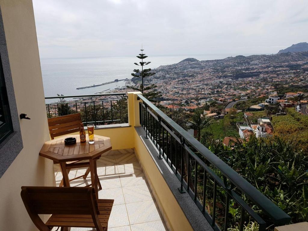 een balkon met een tafel en stoelen en de oceaan bij Apartment with beautiful ocean and city view in Funchal