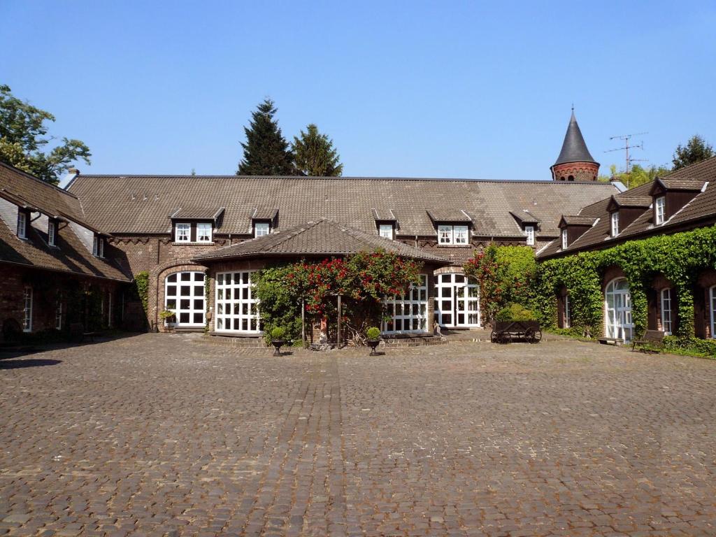 ein großes Gebäude mit einem gemauerten Innenhof davor in der Unterkunft Falderhof in Köln