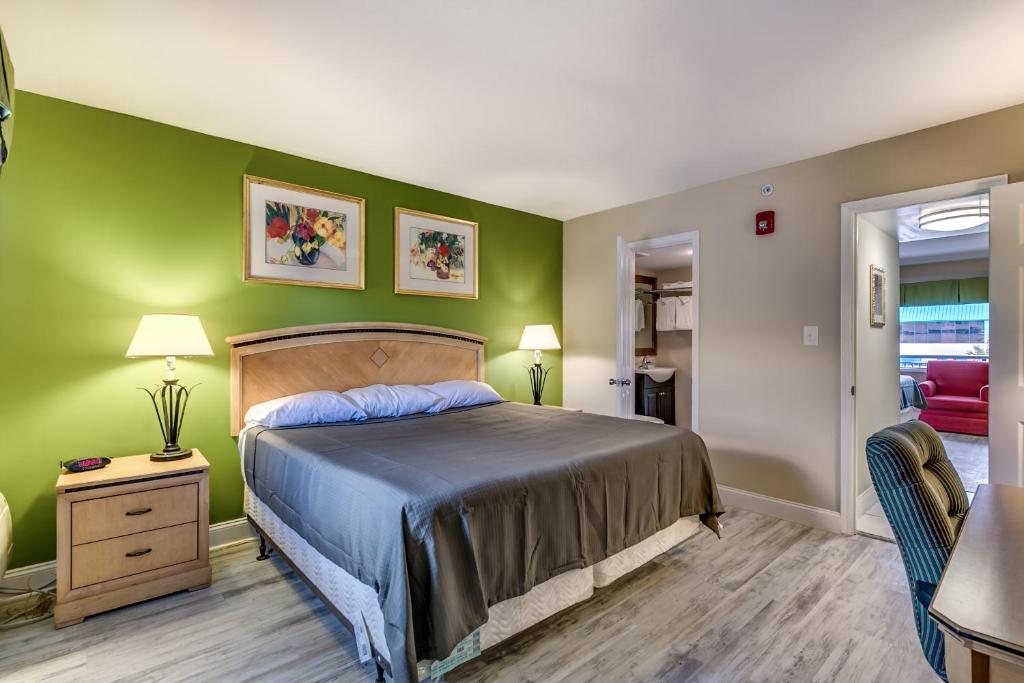 a bedroom with a bed and a green wall at Beachcomber Inn & Suites in Myrtle Beach