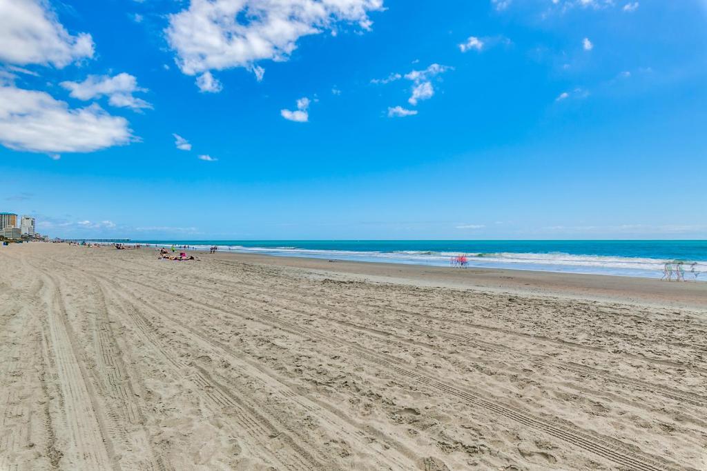 a beach with people on the sand and the ocean at Beachcomber Inn & Suites in Myrtle Beach