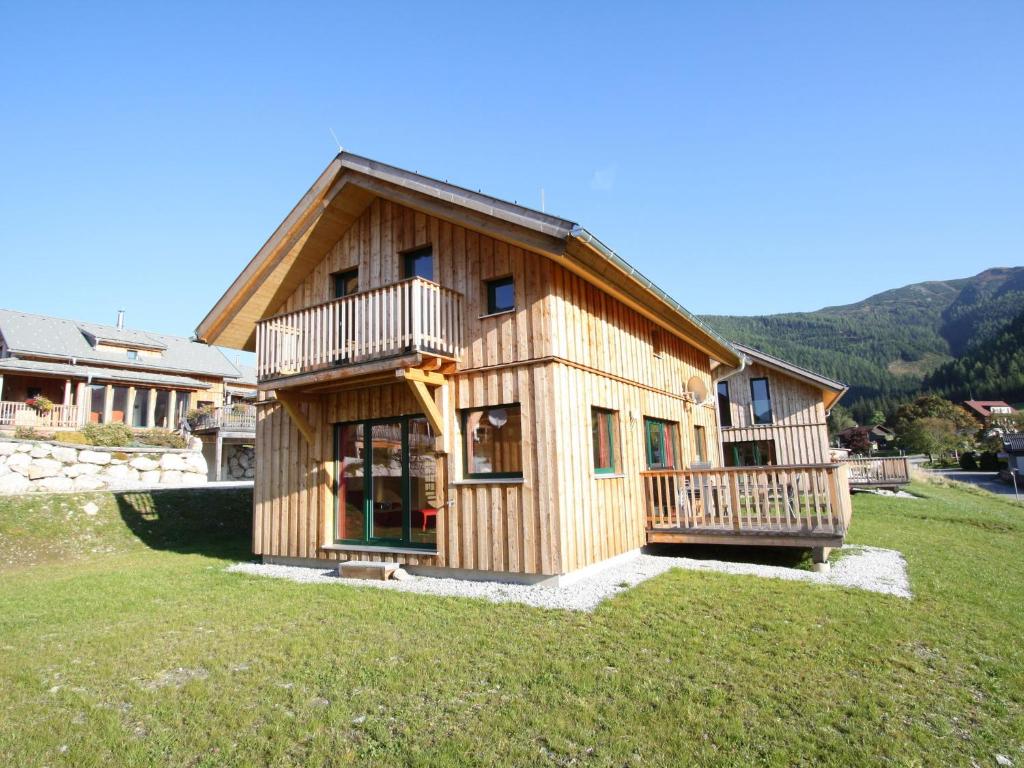 Nice chalet in Hohentauern Styria with sauna في هوهنتاورن: منزل خشبي كبير مع ساحة كبيرة