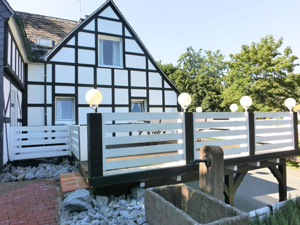 a black and white house with a white fence at Holiday home in Schmallenberg near a ski resort in Schmallenberg