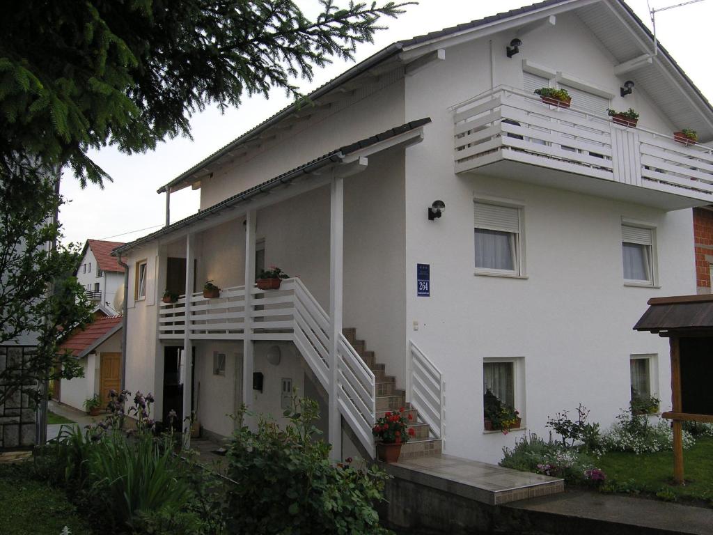 a white building with stairs and flowers on it at Apartments Matijevic in Grabovac