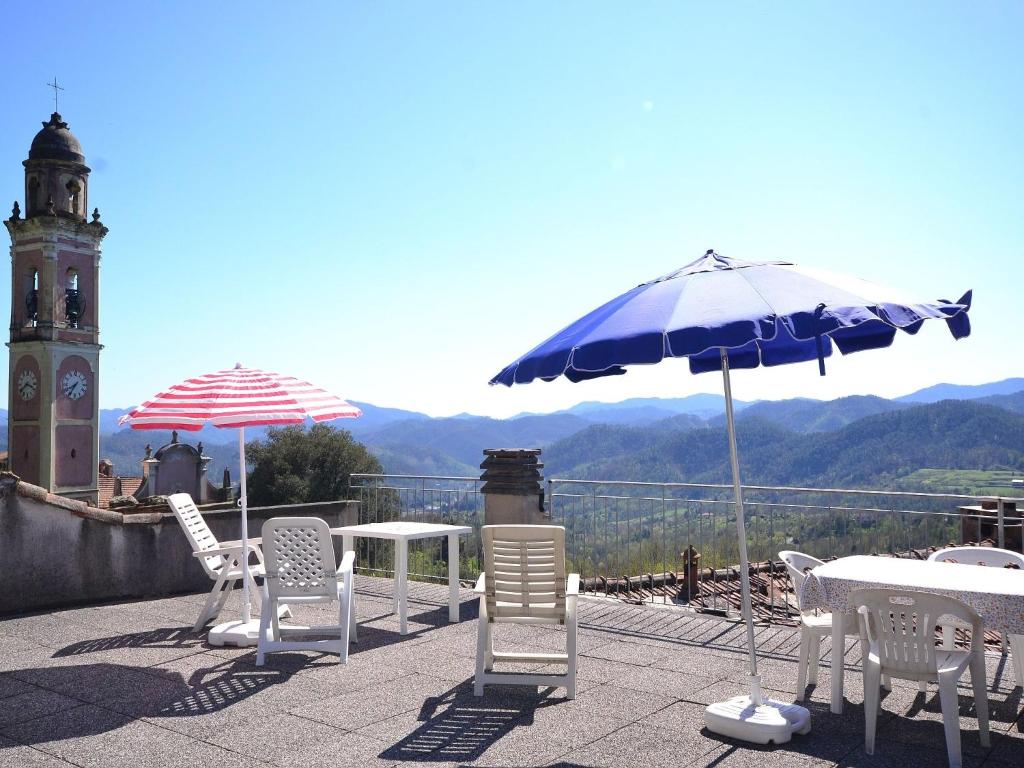 due tavoli e sedie e ombrelloni su un tetto di Flat with terrace 15km from Cinque Terre a Rio