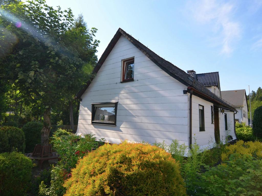 a white house with a window in a garden at Holiday home in Ramsbeck with garden in Ramsbeck