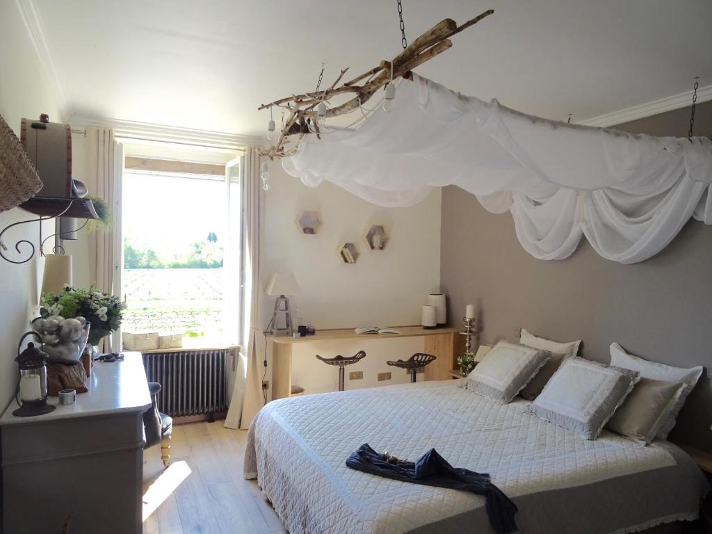 1 dormitorio con 1 cama con dosel blanco en Abacard Home Chambre d'Hôtes adult only, en Roquemaure