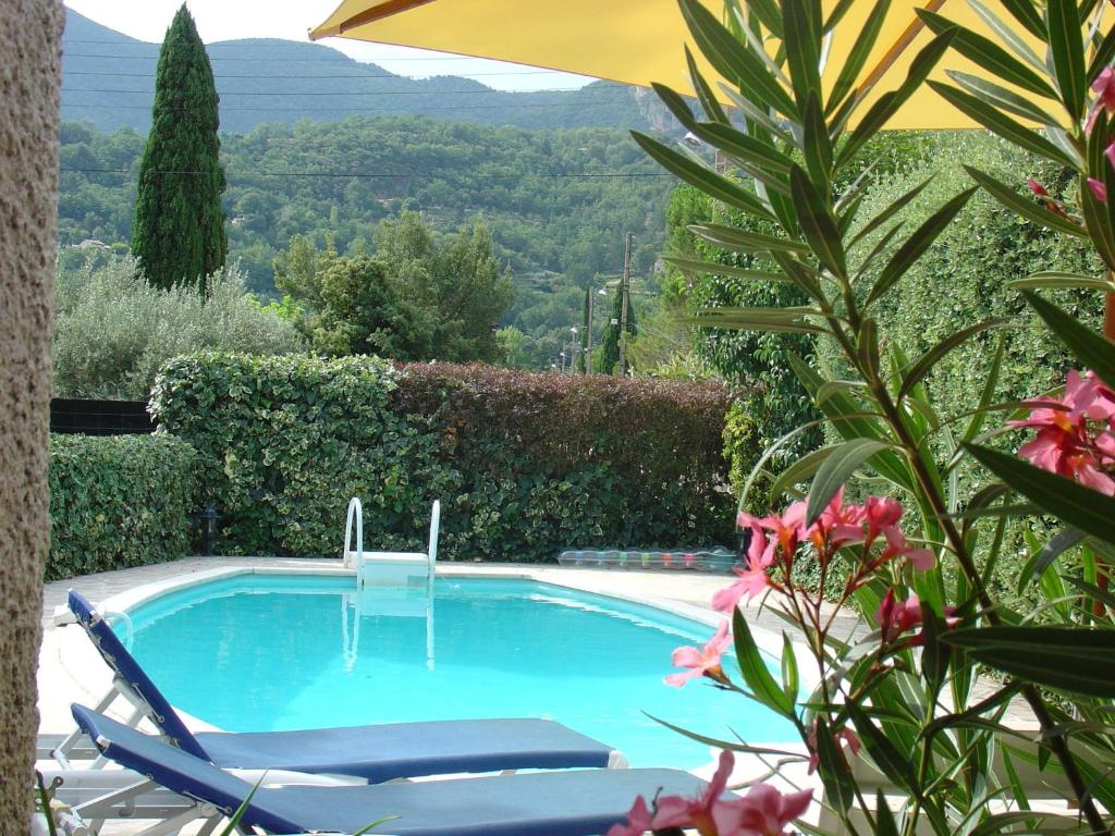 einen Pool mit 2 Stühlen und einem Sonnenschirm in der Unterkunft Beautiful Villa in Nyons with Swimming Pool in Nyons