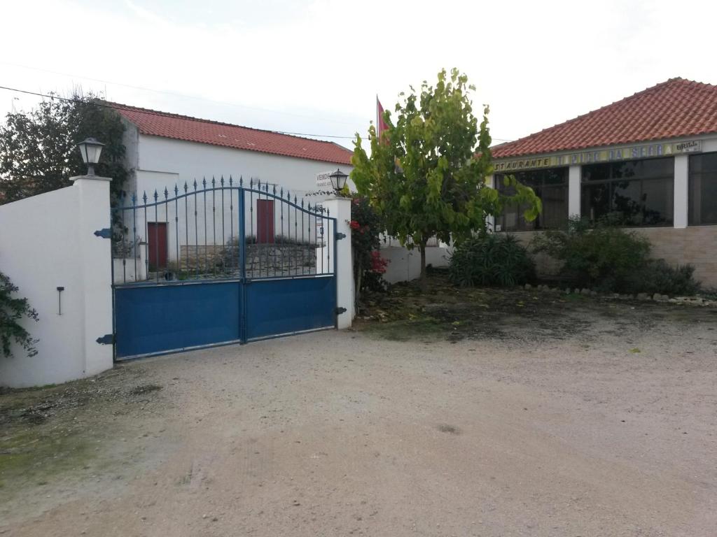 un cancello blu di fronte a una casa di Alojamentos dos Mangues a São Martinho do Porto