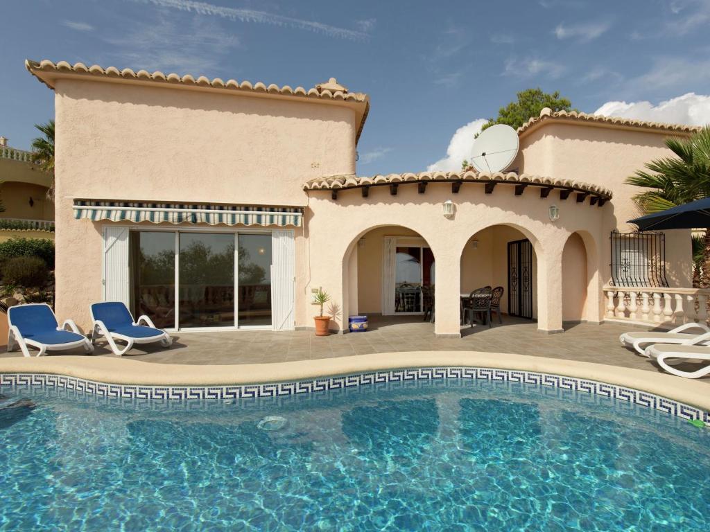Villa con piscina frente a una casa en Belvilla by OYO Magnolias, en Cumbre del Sol