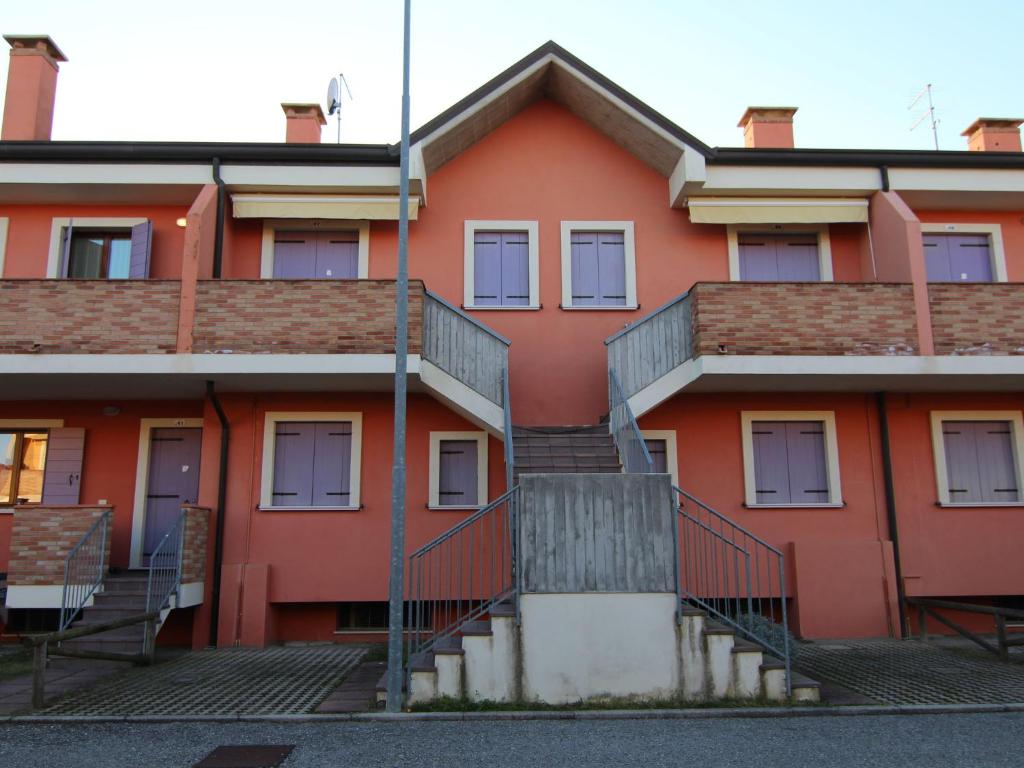 ロゾリーナ・マーレにあるBelvilla by OYO Solmare Bi Cinqueの階段を目の前に建つオレンジ色の建物