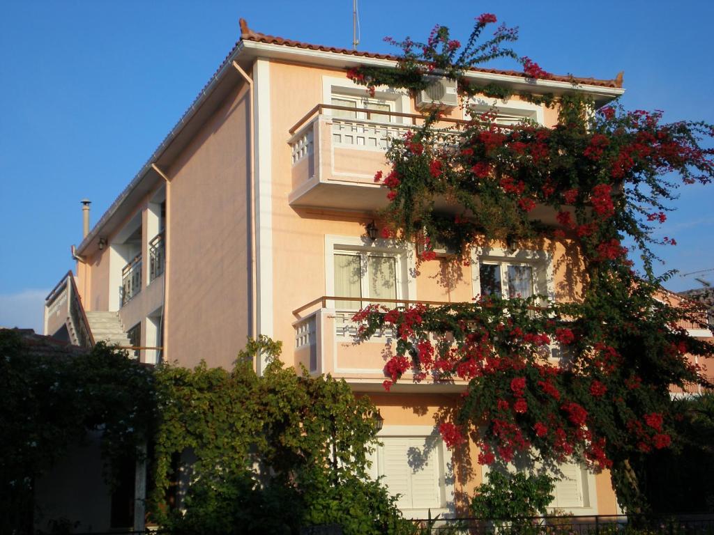budynek z czerwonymi kwiatami na boku w obiekcie Theodora Studios & Apartments w mieście Skála Kefalonias
