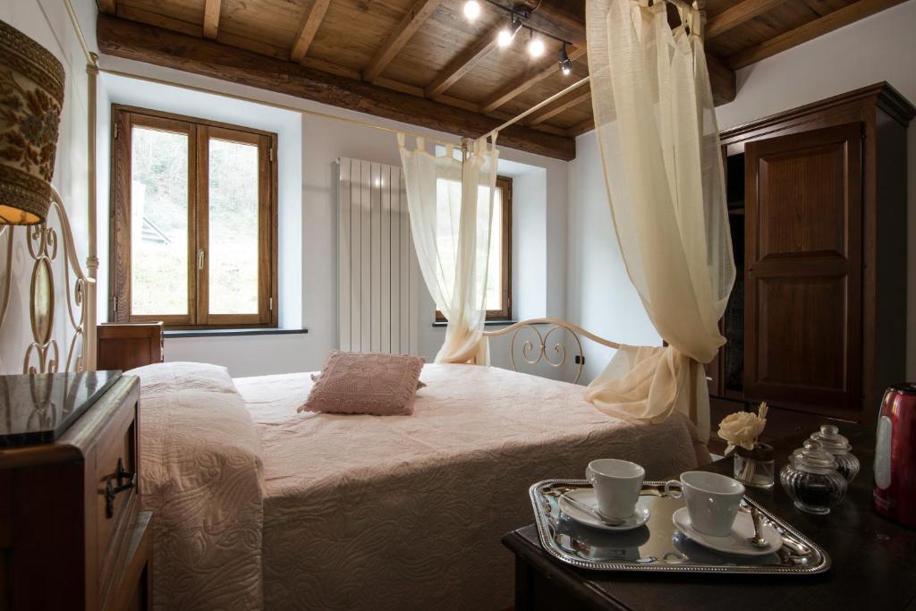 1 dormitorio con 1 cama con 2 tazas y bandeja en Le Casine del Borgo, en Borgo a Mozzano