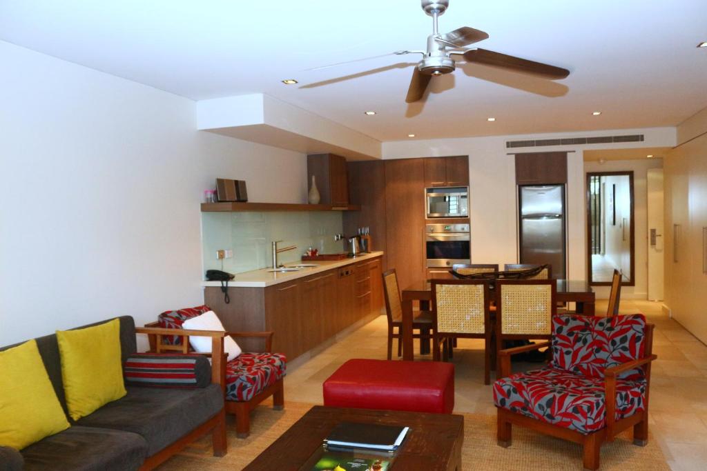 een woonkamer en een keuken met een bank en een tafel bij 422 Temple Beachside Penthouse in Palm Cove