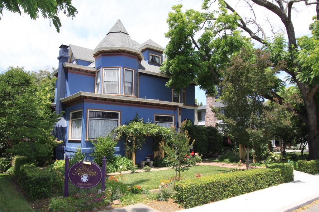 une maison bleue avec un panneau devant elle dans l'établissement The Napa Inn, à Napa