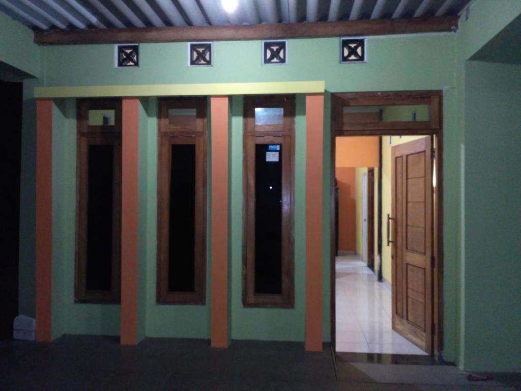un couloir d'une chambre avec trois portes dans l'établissement mas Eko Jlatren kost homestay, à Prambanan