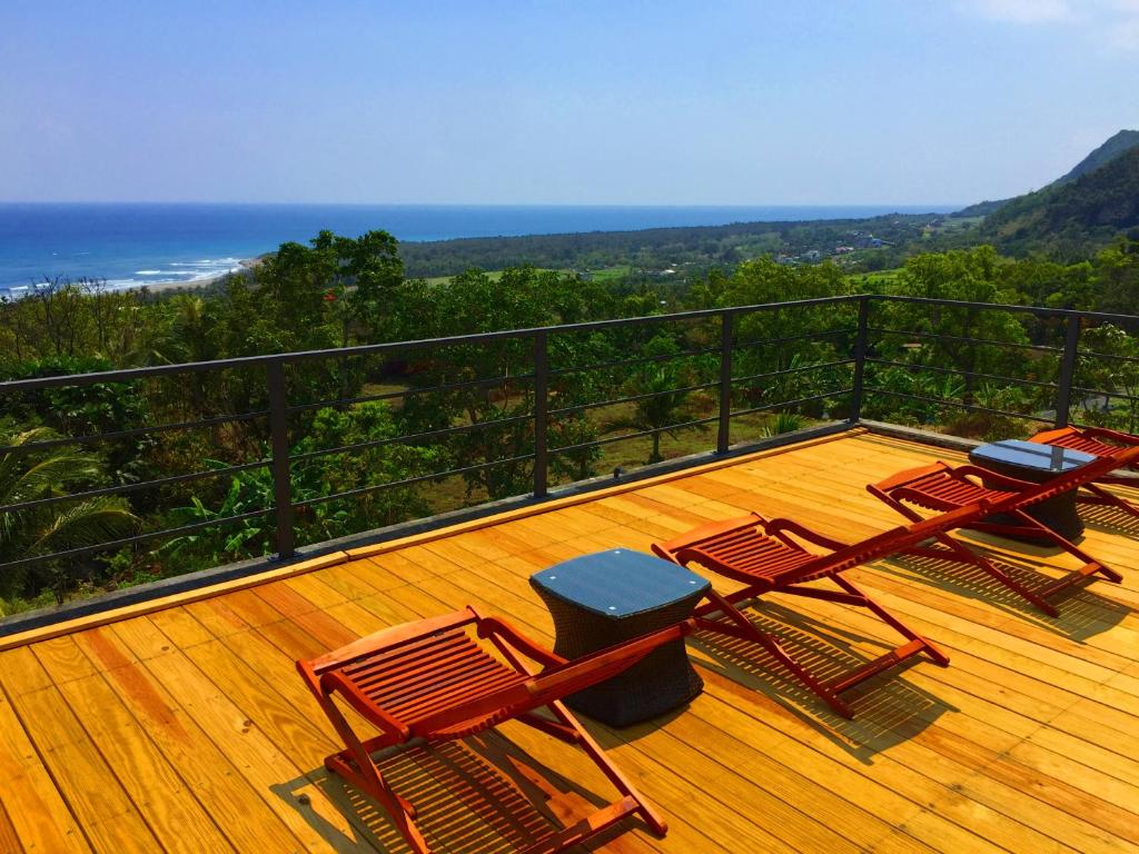 three chairs on a deck with a view of the ocean at David SamStrong Villa 大尾山姆維拉 in Chenggong