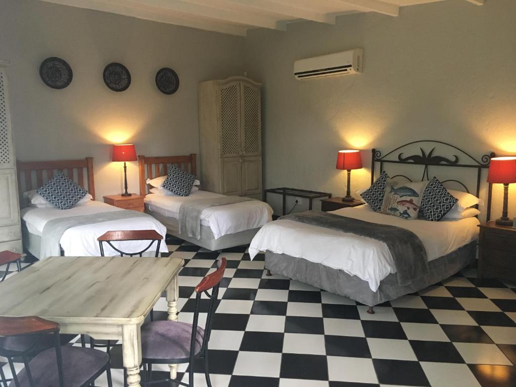 a bedroom with two beds and a checkered floor at Windmills Rest in Pretoria