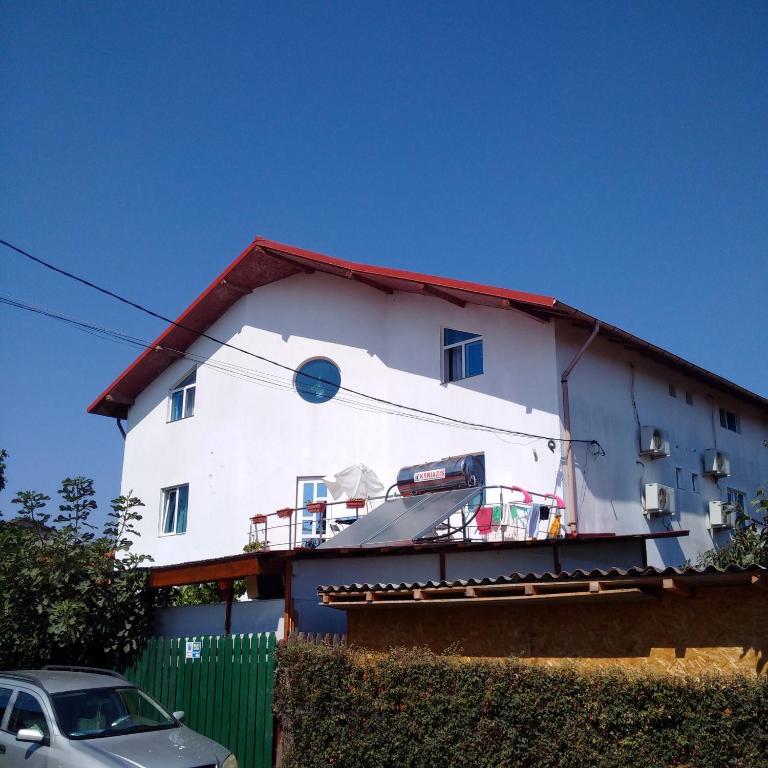 a white house with a car parked in front of it at Casa Carlo in Eforie Nord