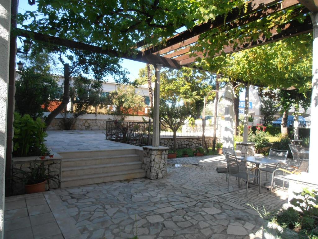 a patio with a table and chairs under a pergola at Hotel Metković in Metković