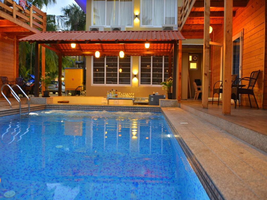a swimming pool in front of a house at Orabella Villas & Suites in Calangute
