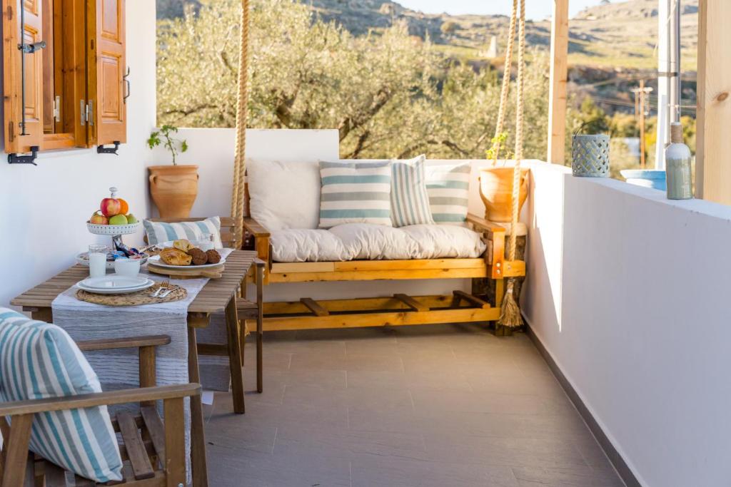 a porch with a swing and a table at Lindos SeaView Apartment in Líndos
