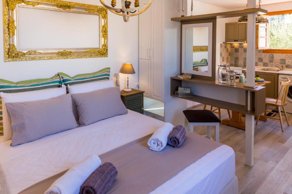 a bedroom with a white bed with a desk and a mirror at Lindos SeaStar Apartment in Lindos