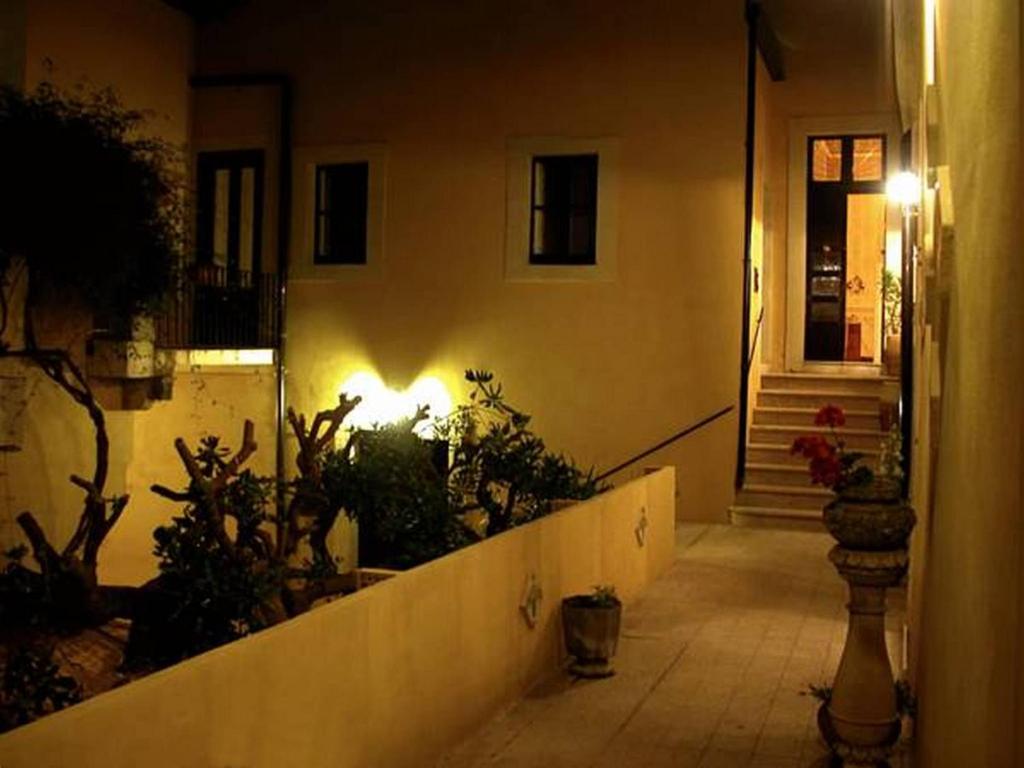 a hallway leading to a house with plants and a light at Il Giardino Del Barocco in Noto