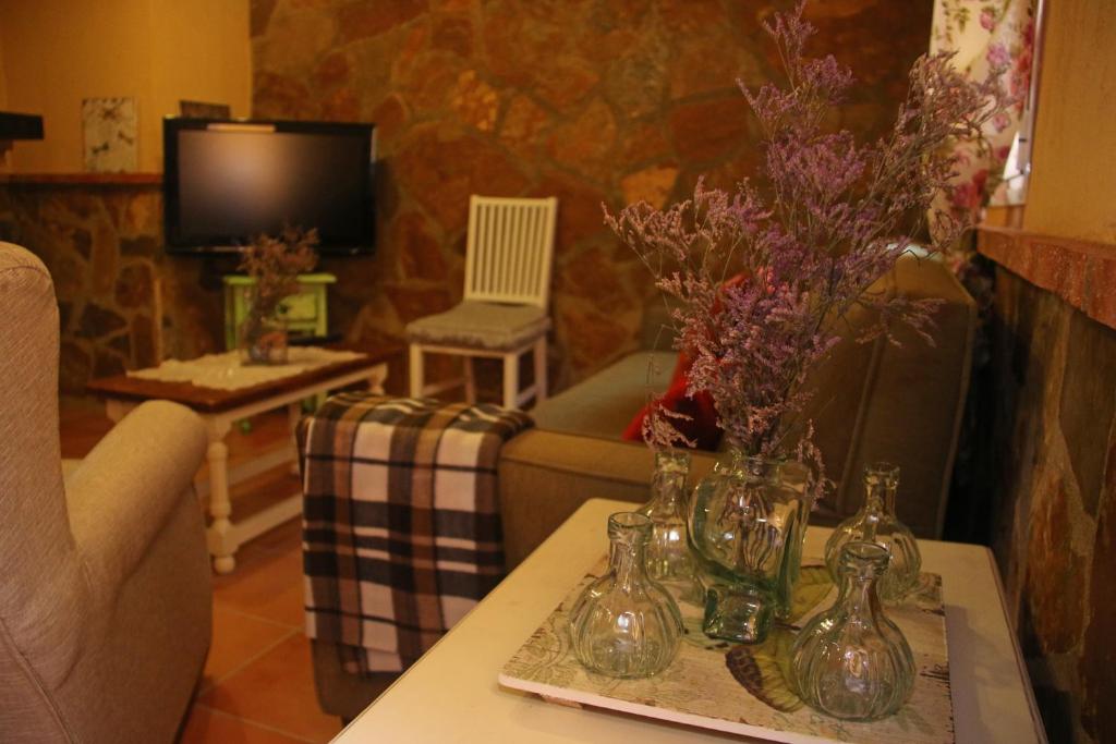 sala de estar con sofá y mesa con flores en Casa Rural Sierra De Coripe, en Coripe