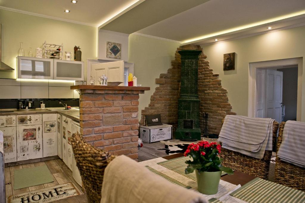 eine Küche mit einem Tisch und einem gemauerten Kamin in der Unterkunft Gyulai 200 Éves Apartman in Gyula