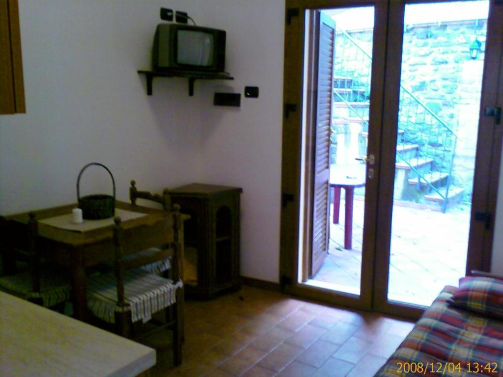 sala de estar con TV y puerta corredera de cristal en Casa Vacanze Del Pescatore, en Passignano sul Trasimeno