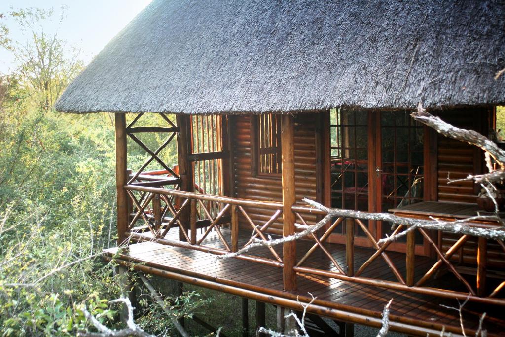 a small hut with a thatched roof at Lion Tree Bush Lodge in Marloth Park